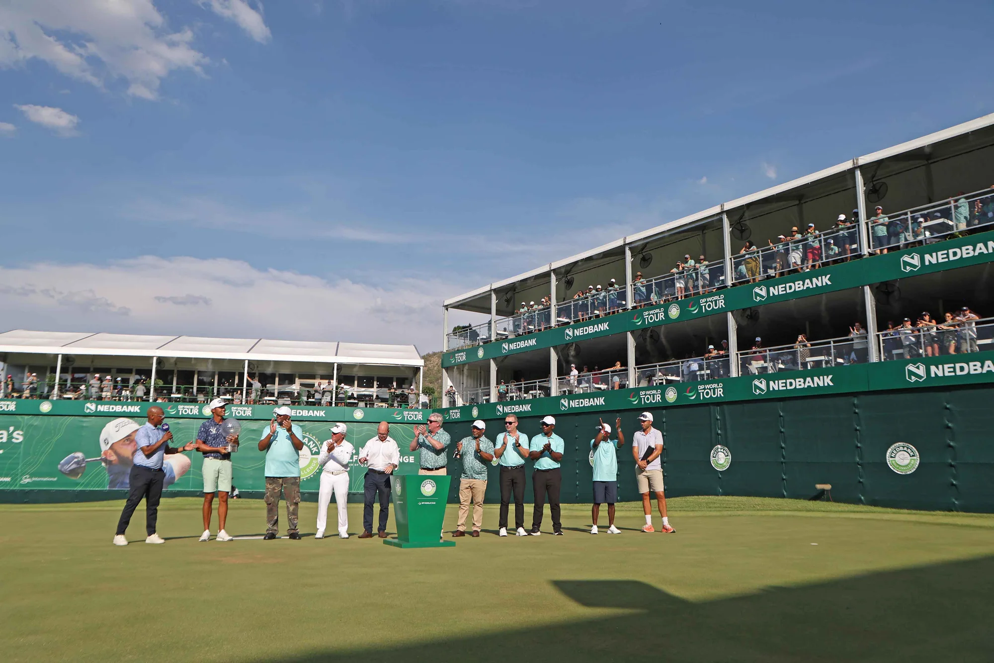 Golfers beside the Nedbank Golf Challenge grandstand